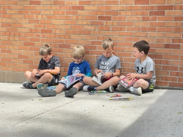 First graders reading outside for their count down to summer.